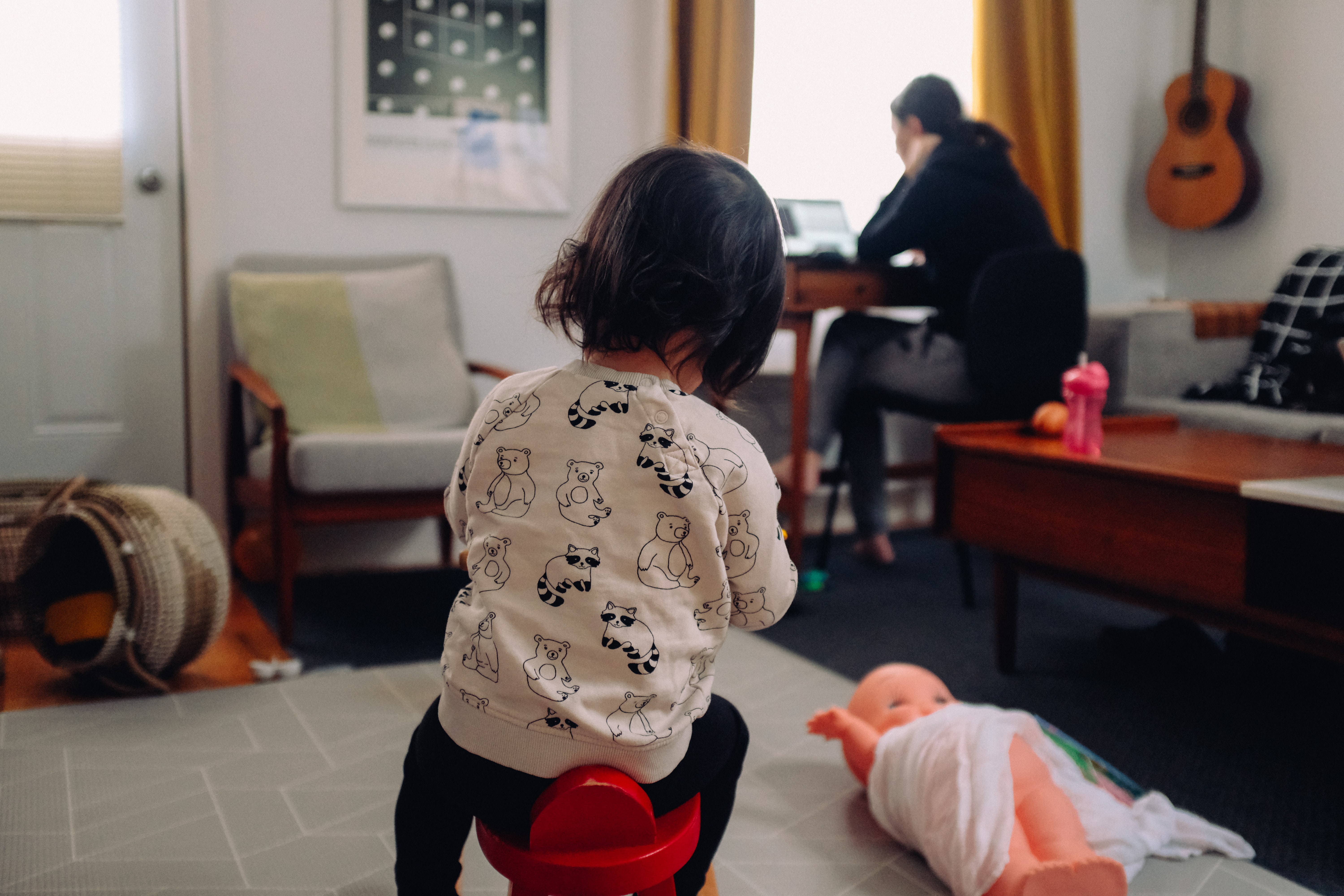 Toddler playing behind person working. Thanks to Charles Deluvio for sharing their work on Unsplash.